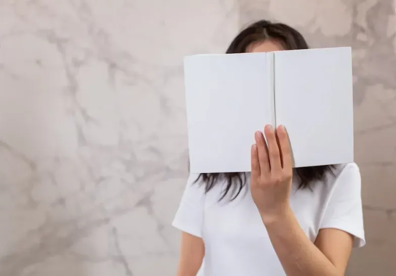 une femme lit un livre blanc